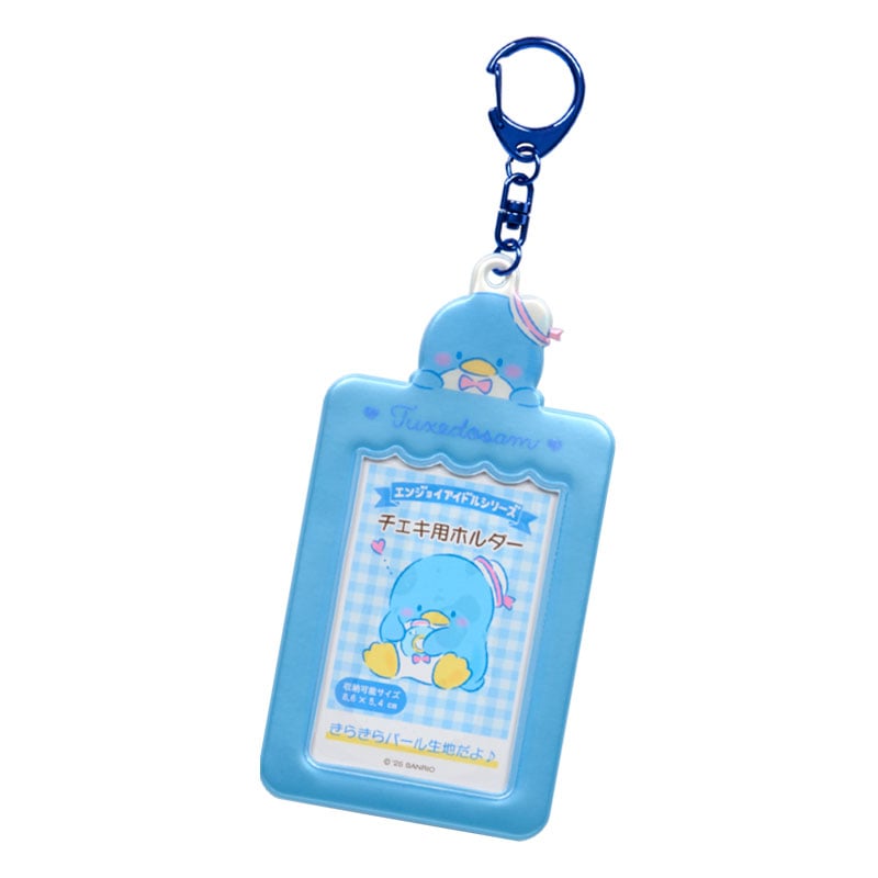 Tuxedosam charm keychain clipped to a denim backpack, holding a photo